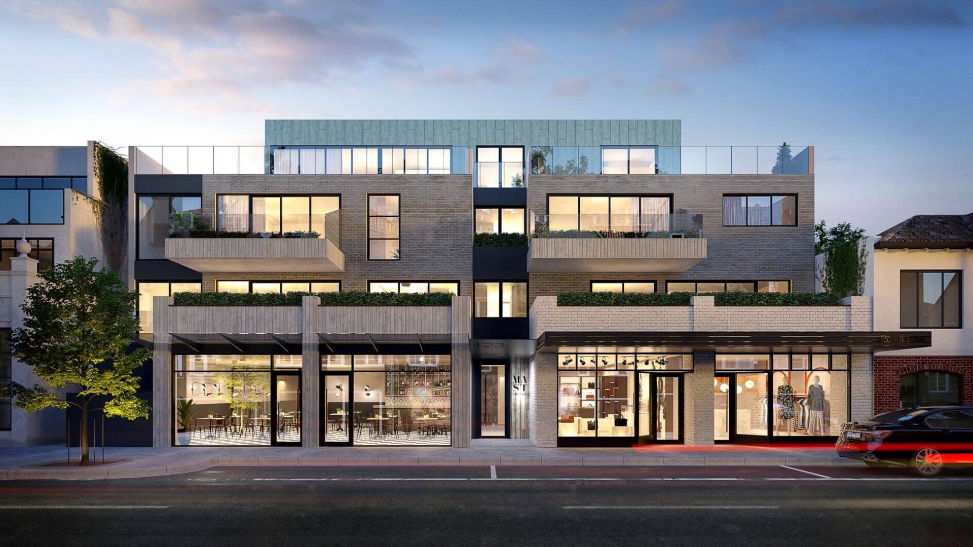 boutique multi-story home with large windows and all lights on.