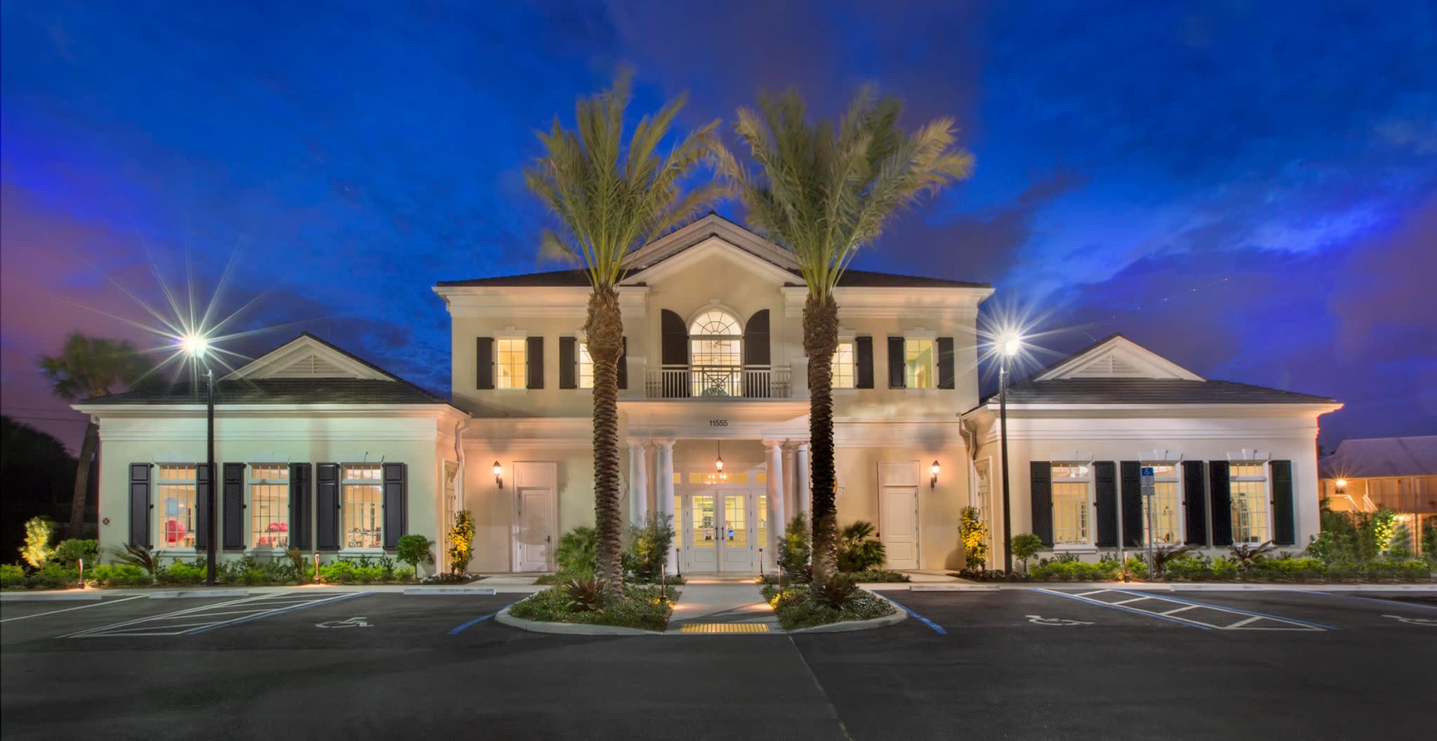 A large white home illuminated at night