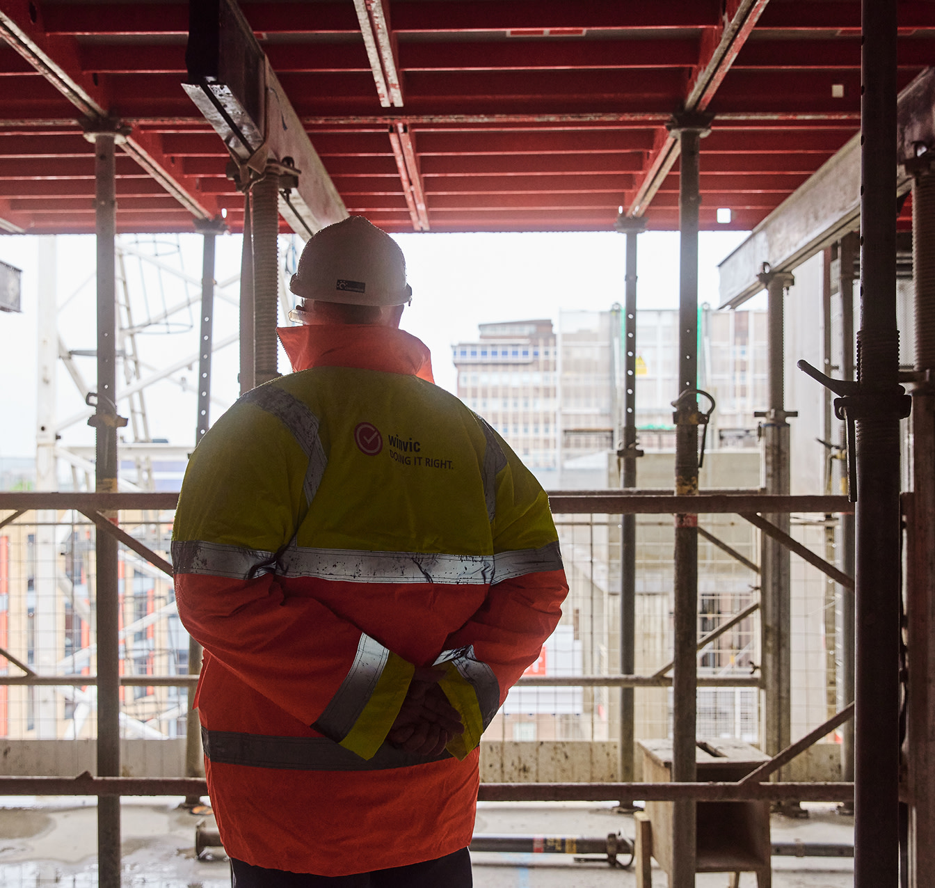 A construction worker looking out from a construction