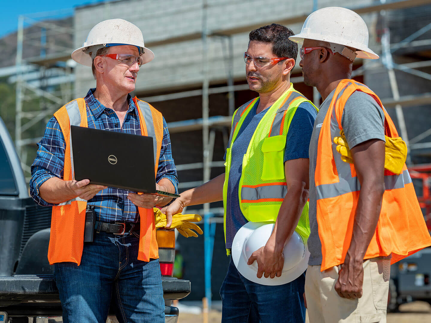 Workers discussing building plans on a jobsite.