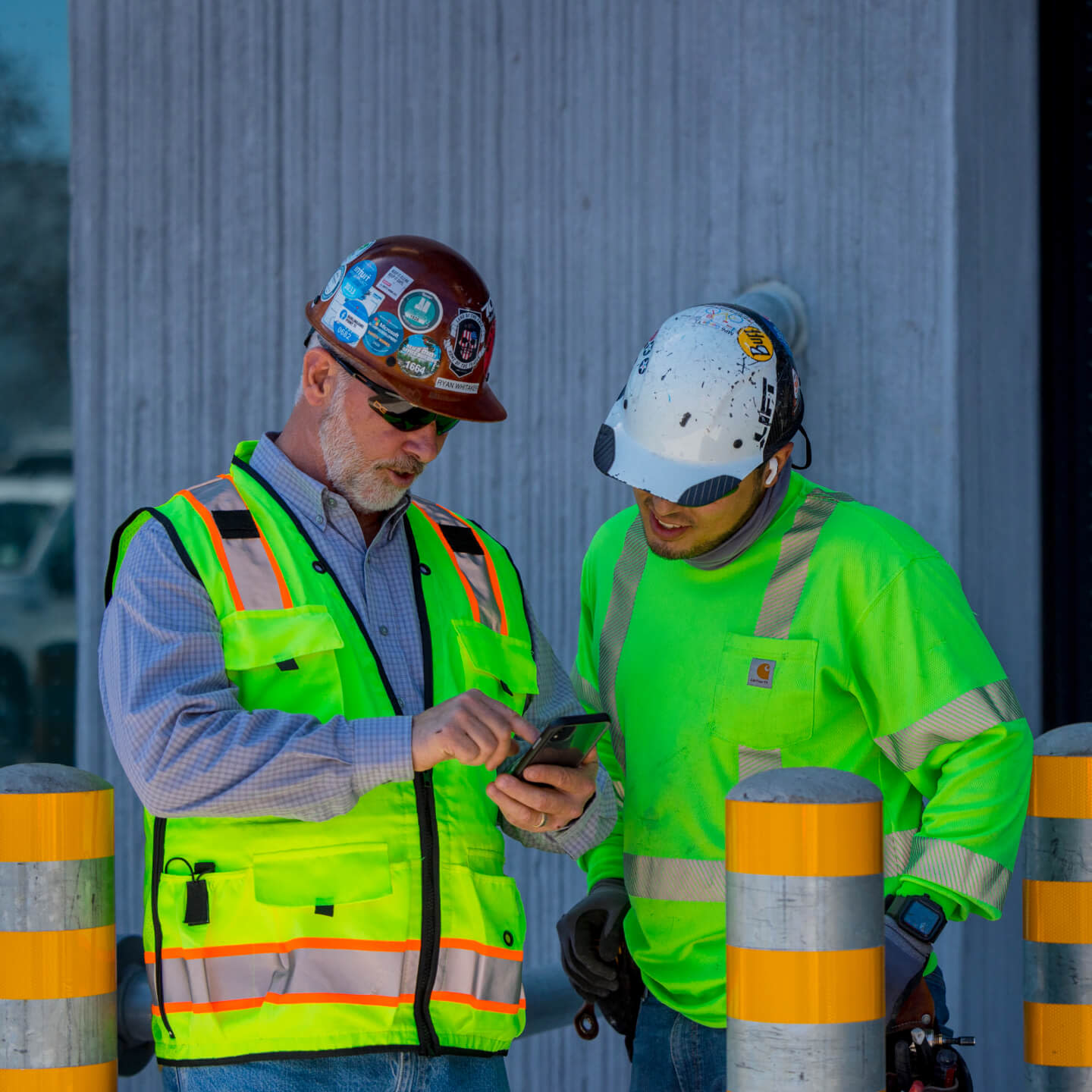 Specialty contractors checking data on Procore on a phone