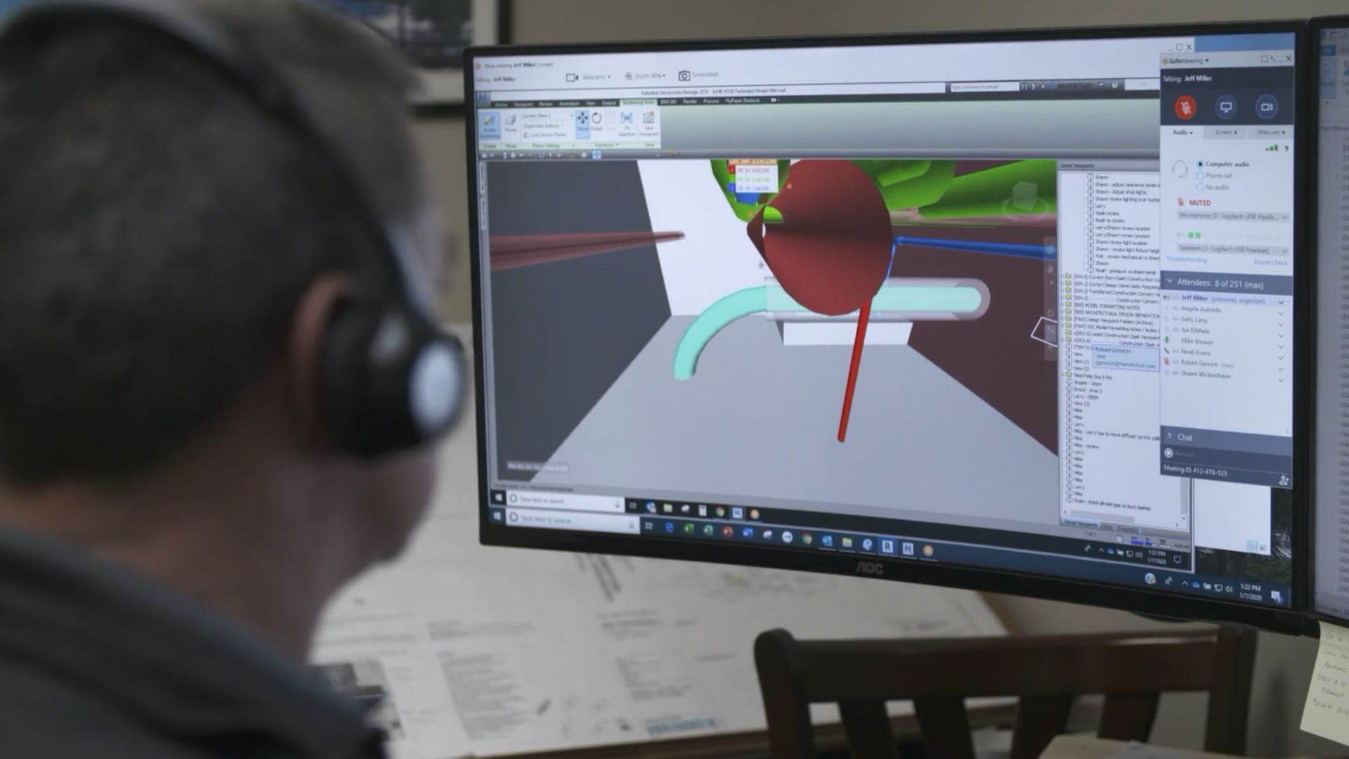 Person sitting at computer viewing a 3D model of a building