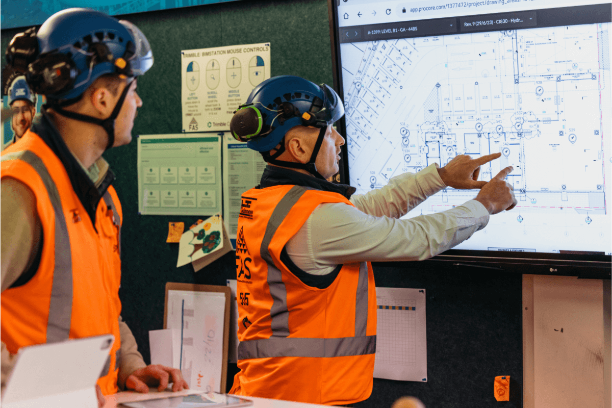 Construction workers looking at a blueprint on a screen