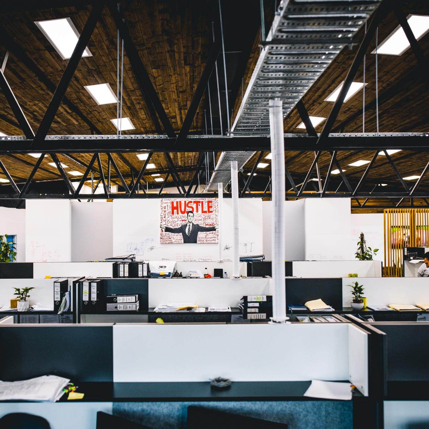 The inside of a trendy office space with a poster with "hustle" on the wall.