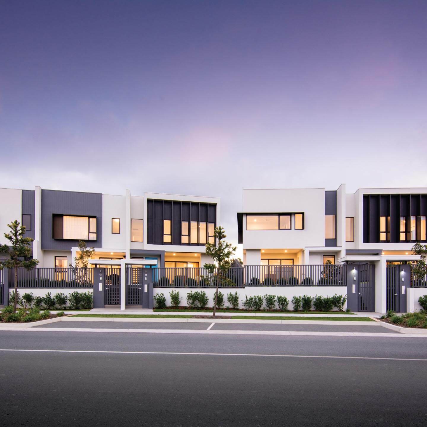 A front shot of multiple white brick houses.