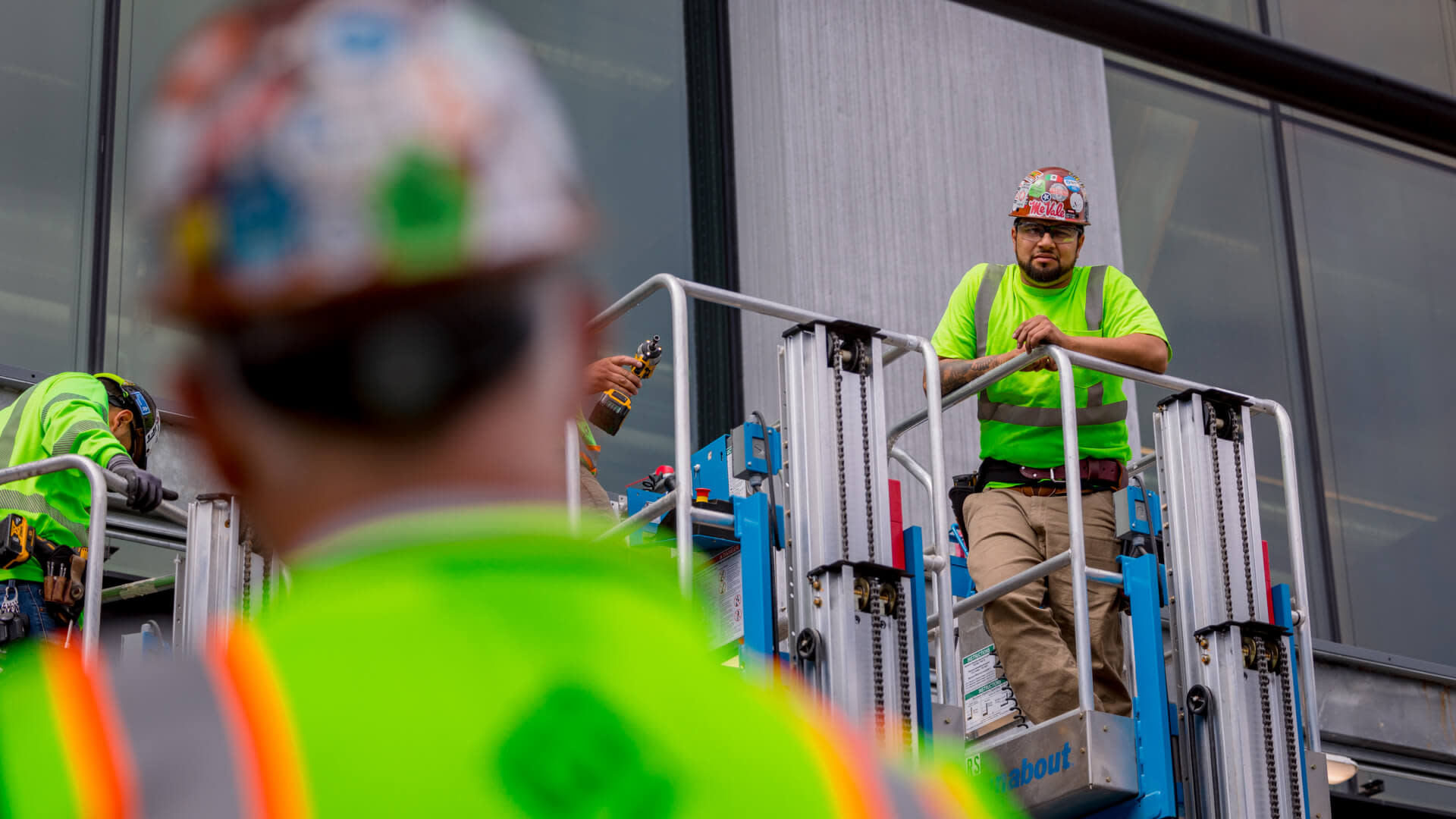 Specialty contractor speaking to another one from a lift