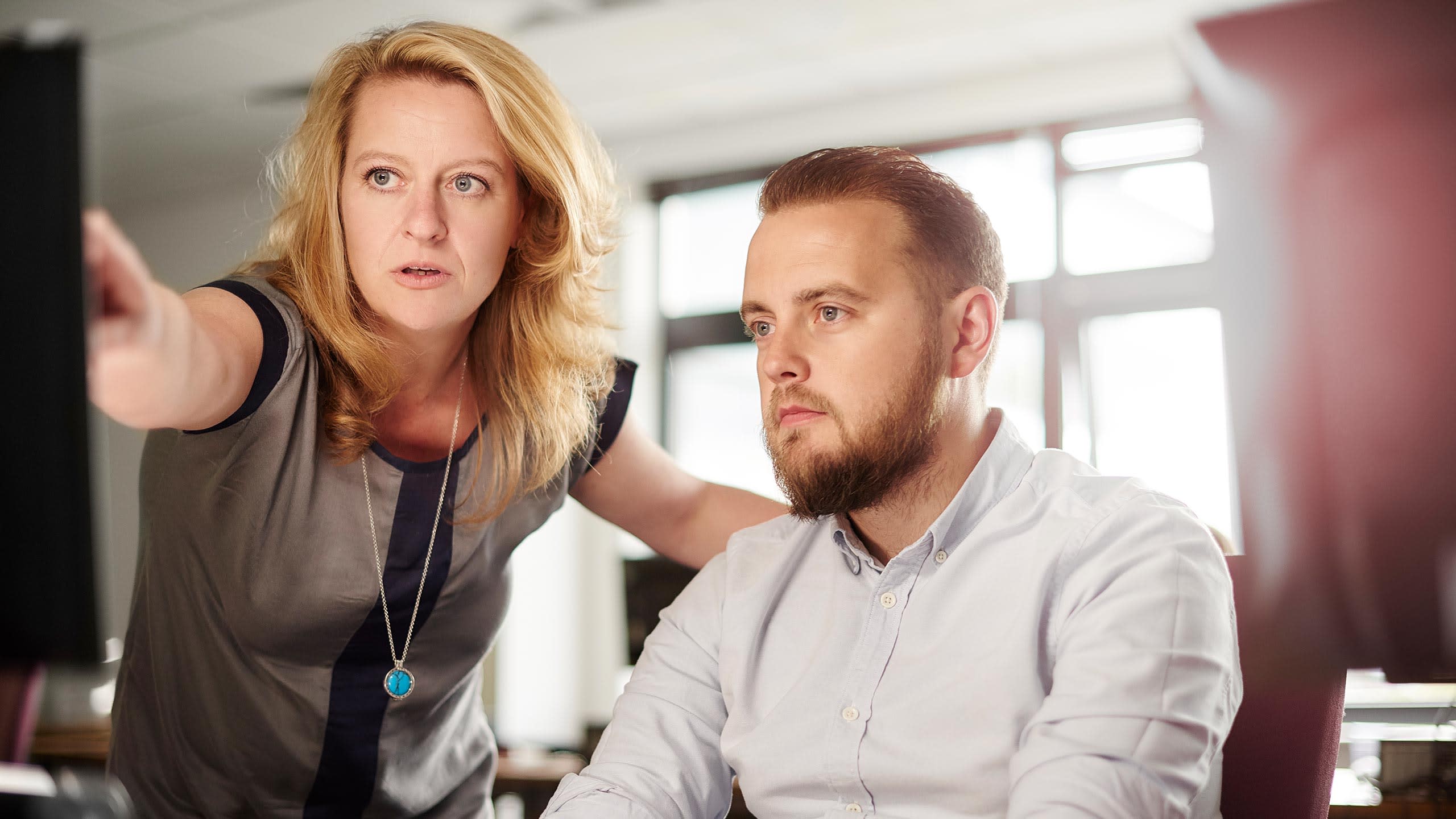 Woman helping a man on his computer