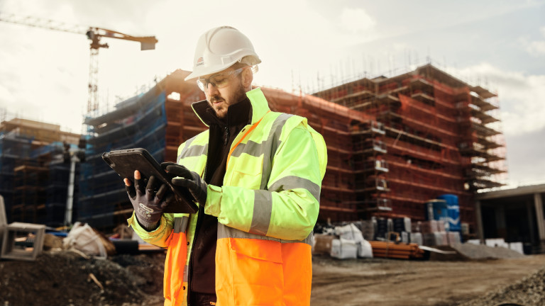 A contractor using a tablet on a construction site