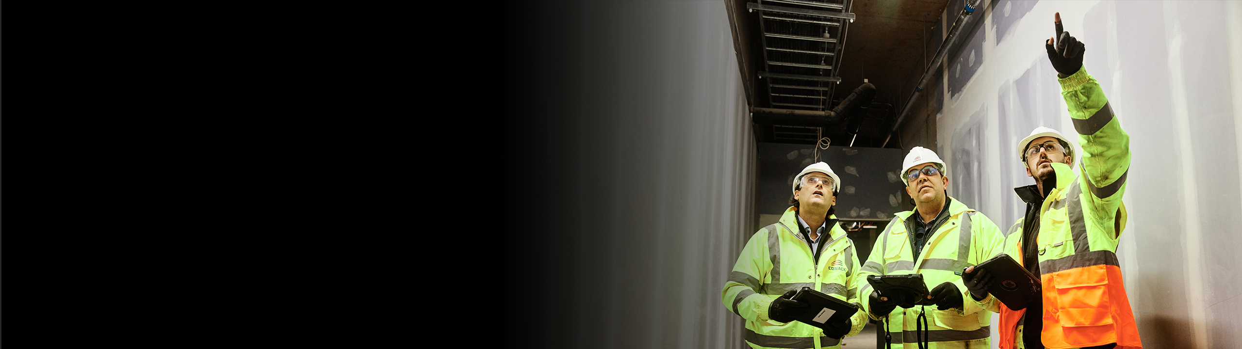 construction workers with ppe inspecting a jobsite with tablets