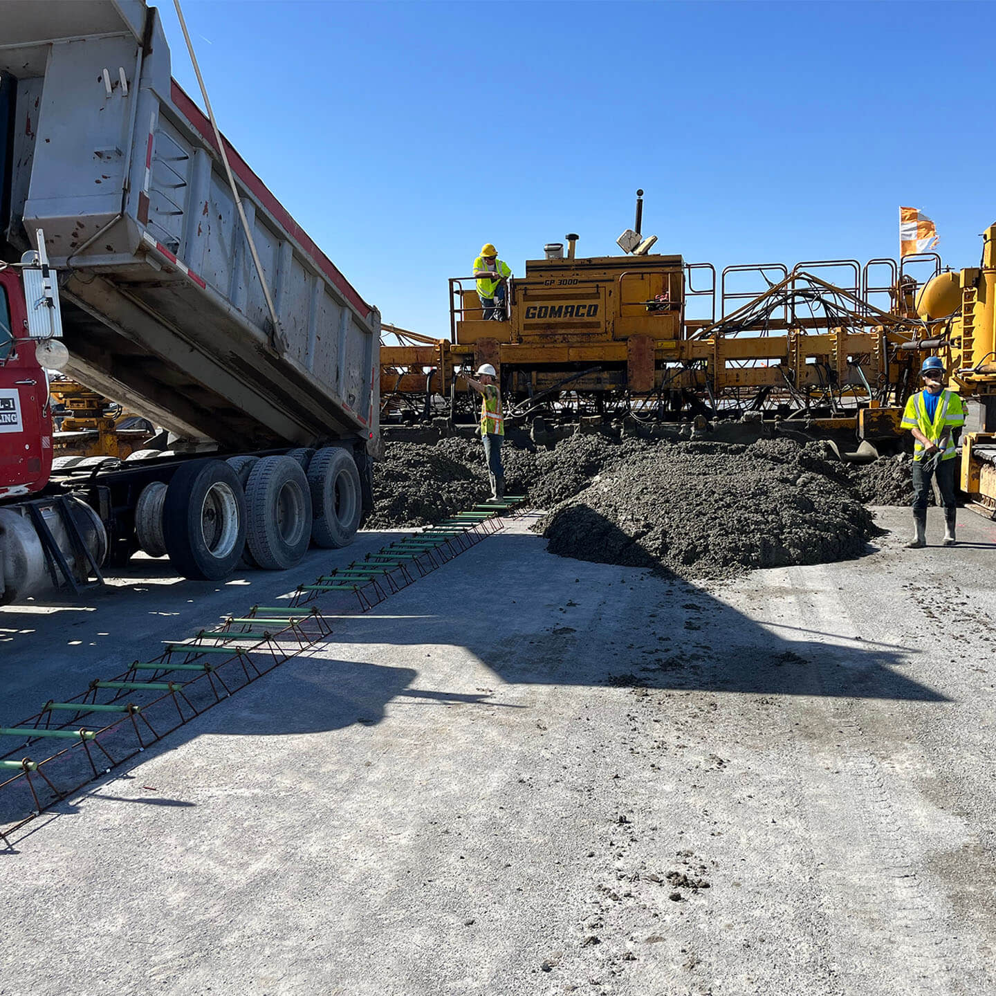 A group of construction workers pouring down rocks