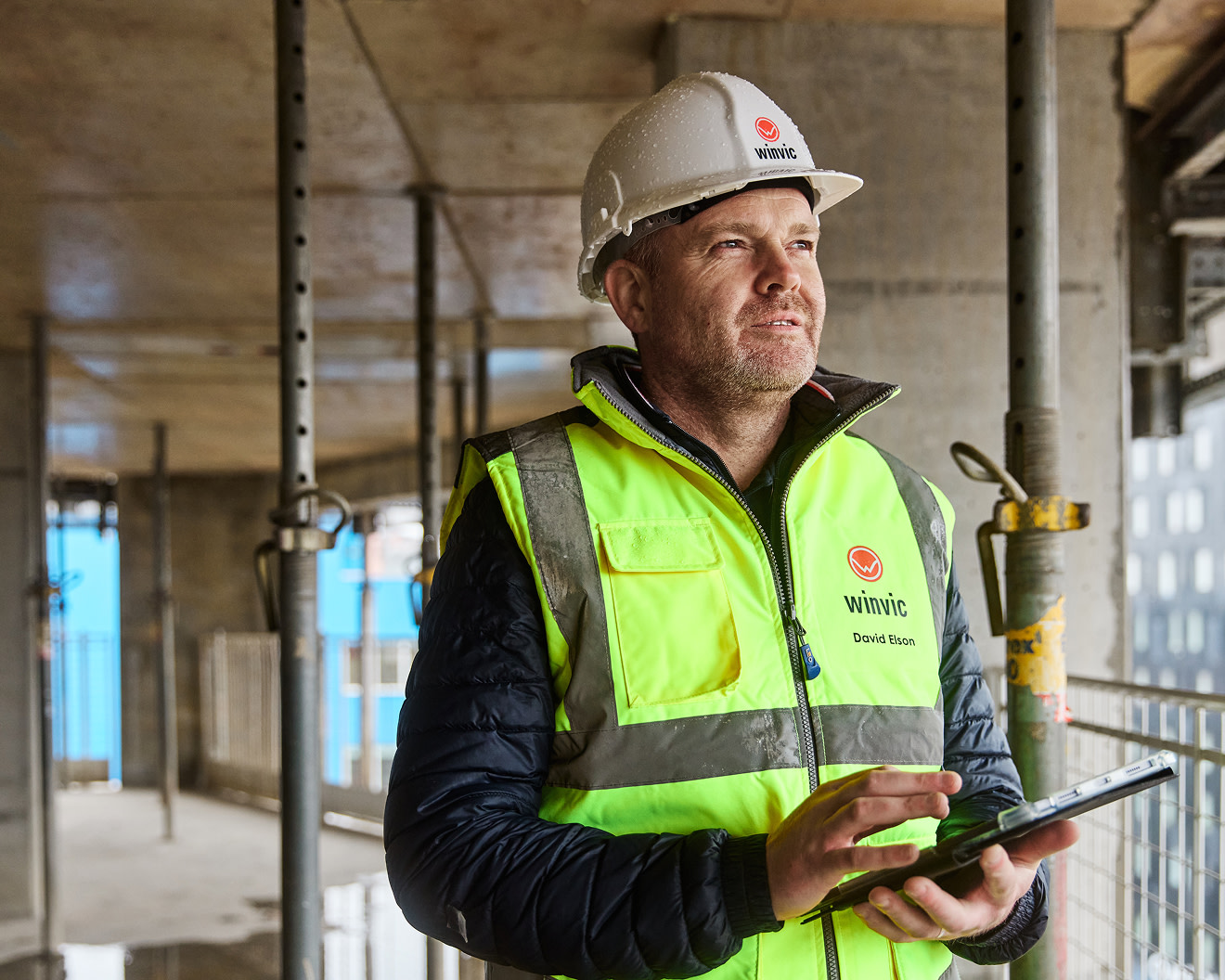 A construction worker using a tablet on site