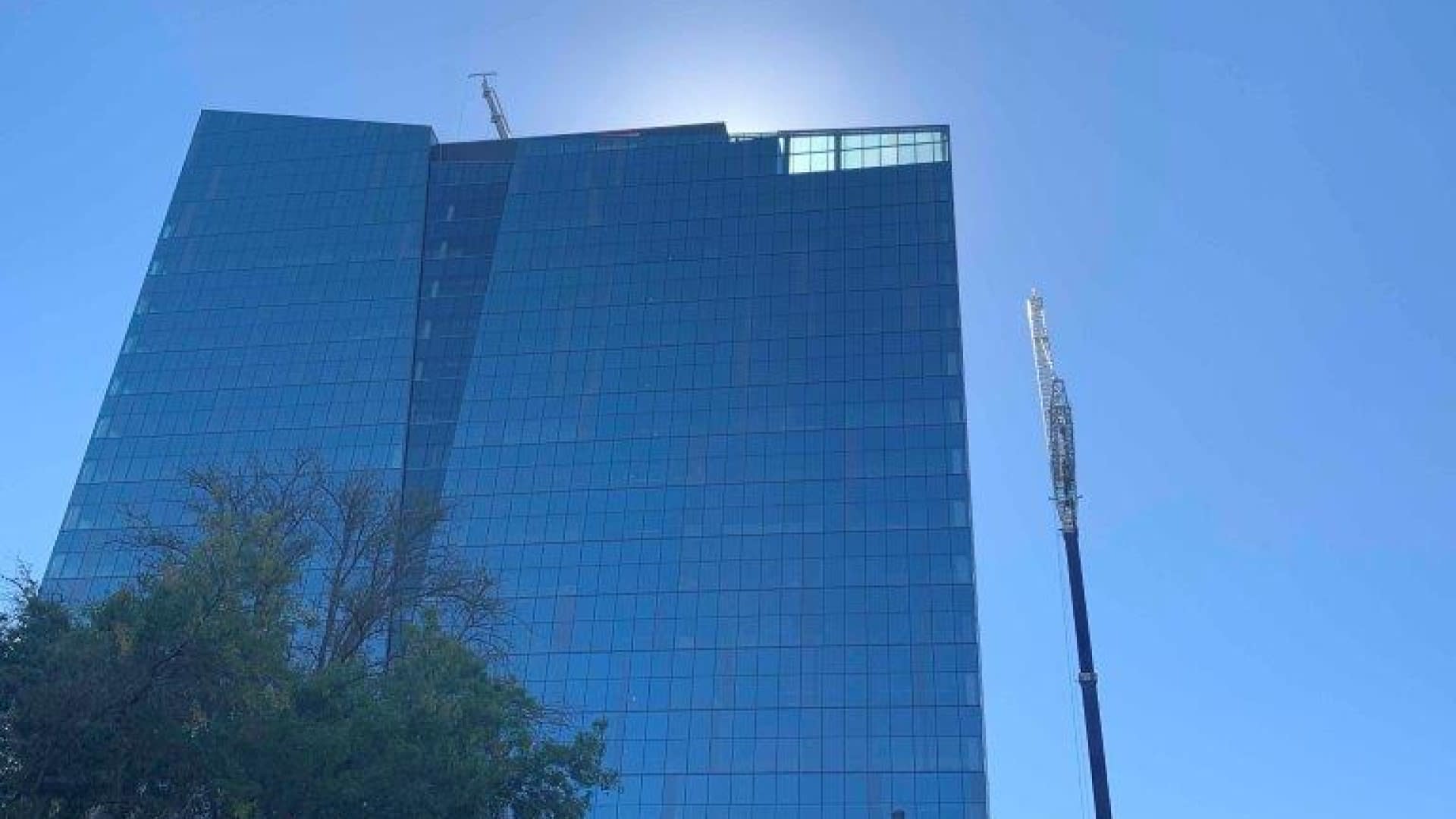 Low angle shot of glass mirrored building with the sun behind it