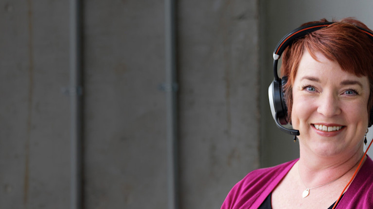 Woman with headphones on smiling to the camera