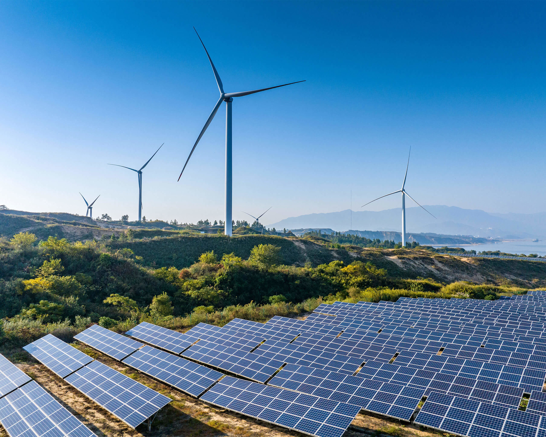 Aerial view of solar panels on a lake with the sun rising in the background
