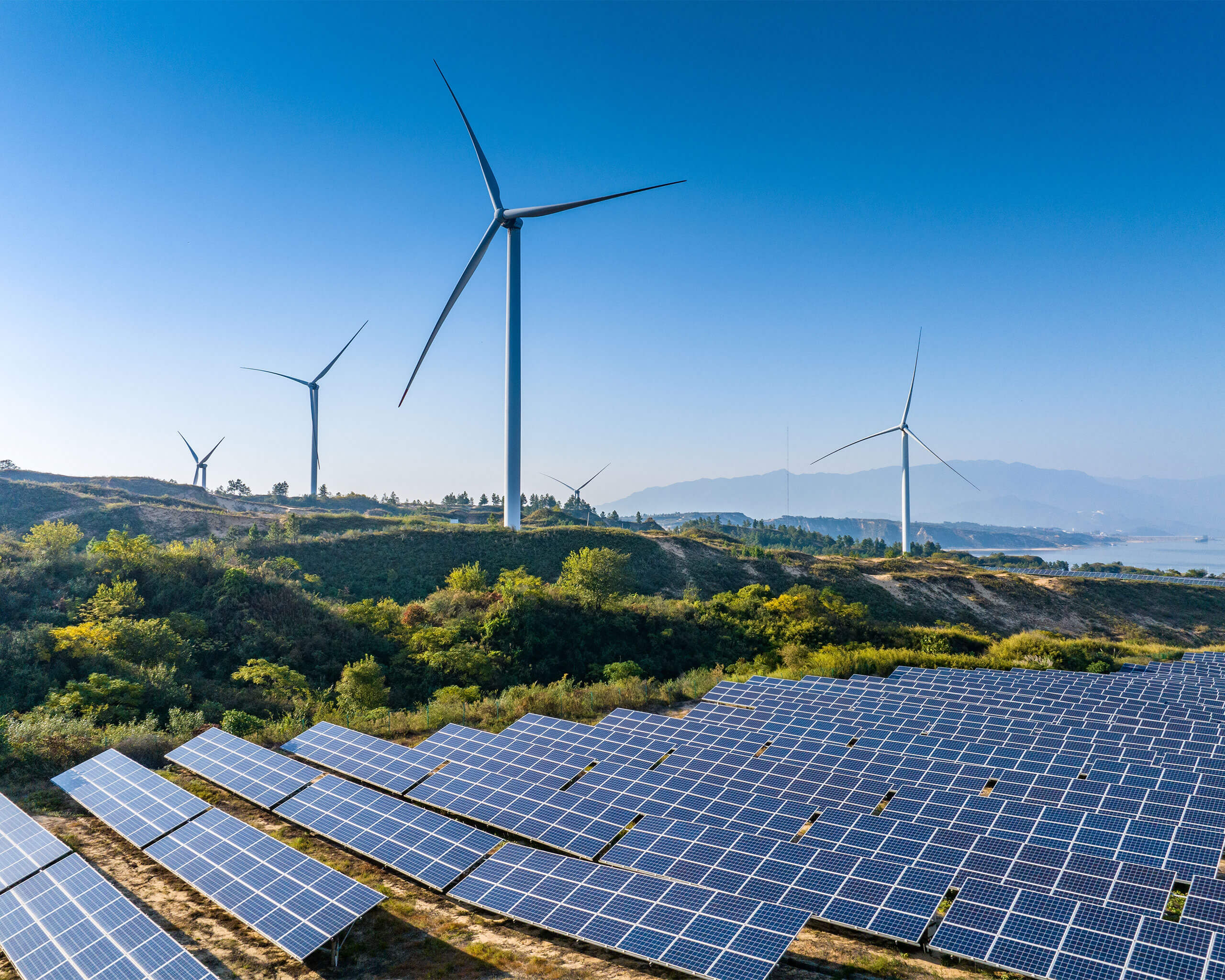 Aerial view of solar panels on a lake with the sun rising in the background