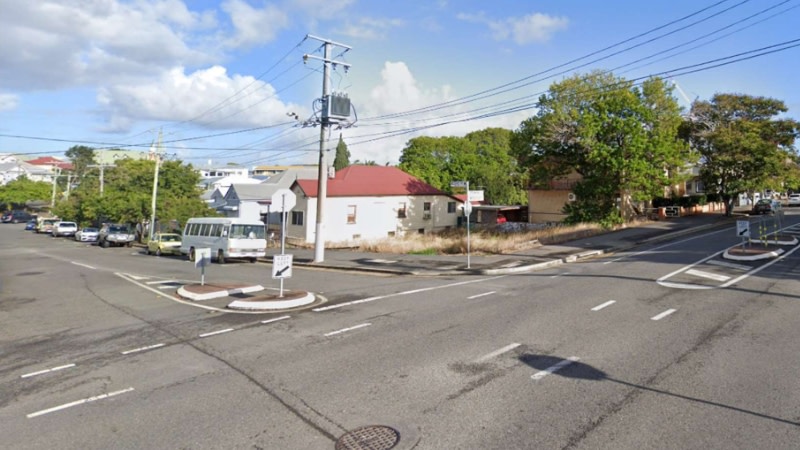 picture of a spare block of land at the corner of a street in south brisbane surrounded by low density homes.