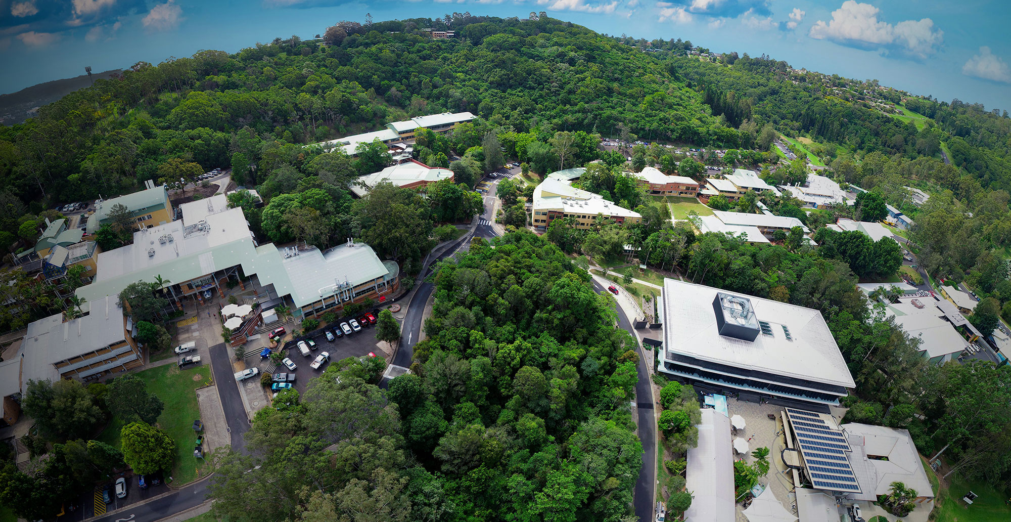aerial image of a low-set university in Lismore surrounded by trees.
