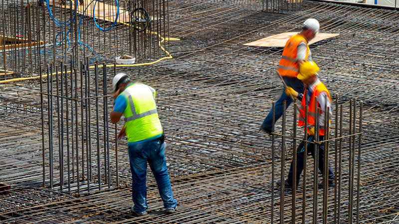 steel workers laying out reinforced rods ready for a concrete pour