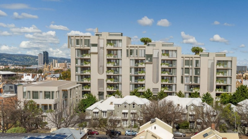a side on rendering of a long 8-storey building with multiple rooftop terraces