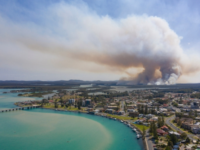 An image of the NSW town of Tuncurry with a bushfire nearby.