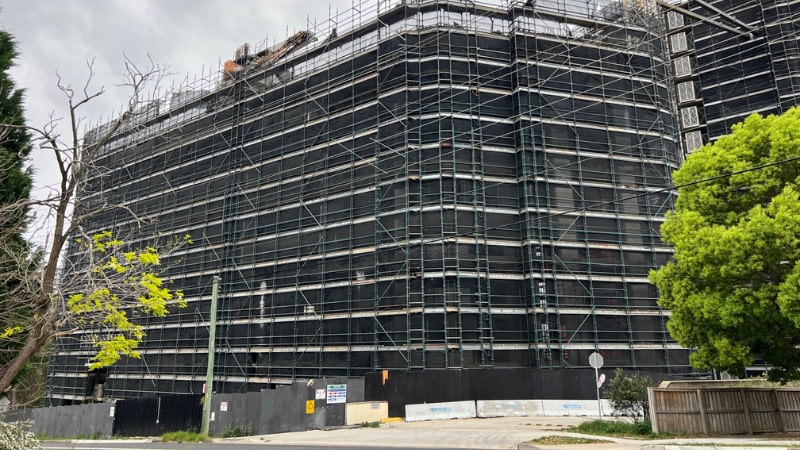 image of a half complete building in Castle Hills, it is covered in scaffolding and had abandoned equipment on it.