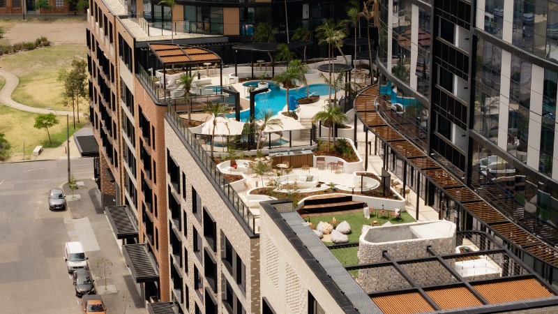 a podium of a build to rent tower in South Melbourne with a swimming pool and lawn on top of a podium.