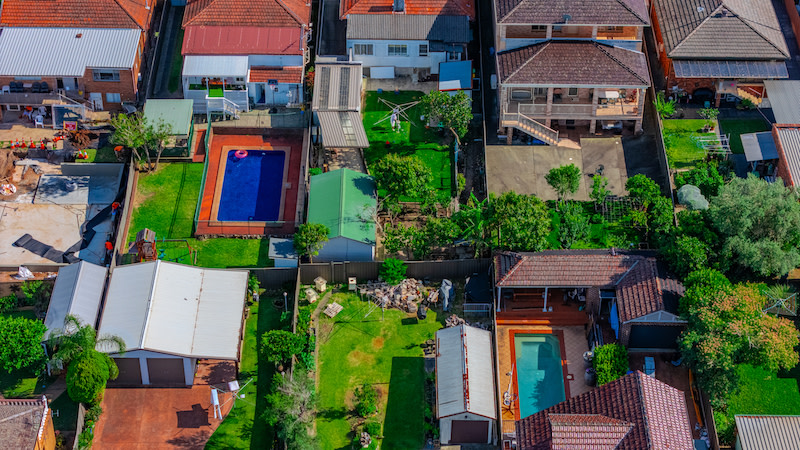 Backyards of homes in NSW's Canterbury region with pools, sheds and porches.