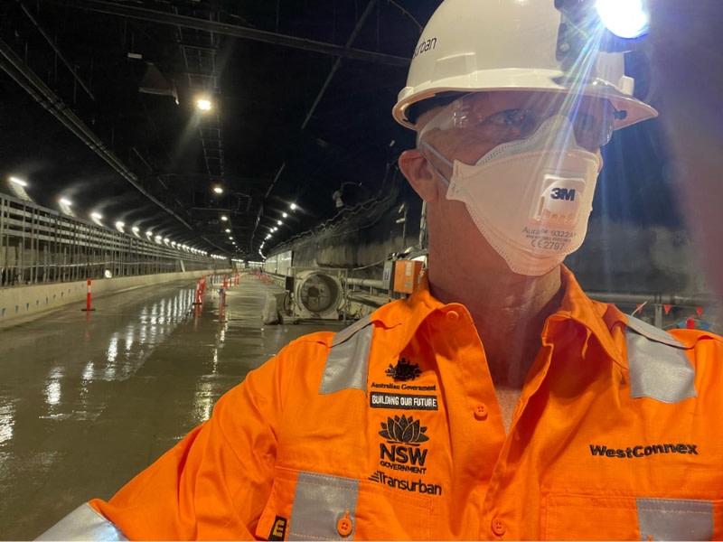 A man in a tight suit and mask in the West Connex tunnel in Sydney