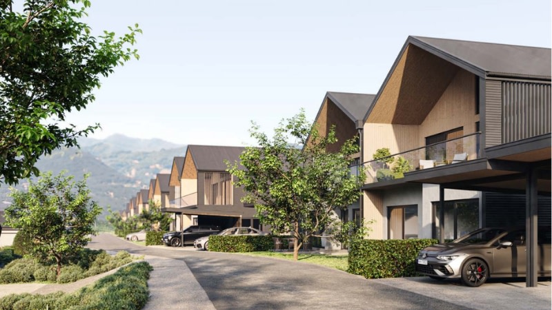 rendering of townhouses on a green street in new zealand with hills in the background