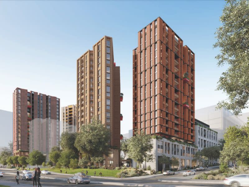 Four high-rise buildings in white, brick and earthy tones next to a busy road in Macquarie Park.