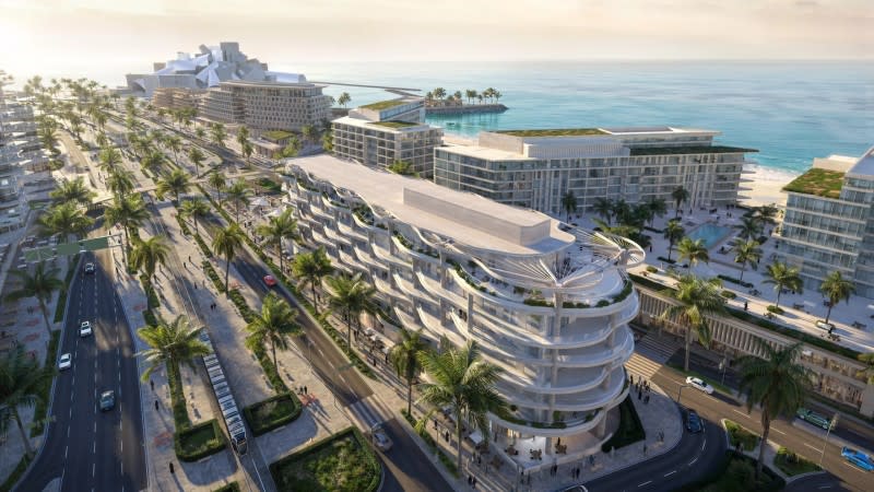 A curvy building in Abu Dhabi near the beach on a sunny day with the  Guggenheim Abu Dhabi in the background.