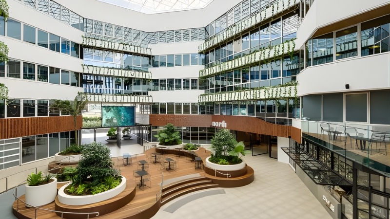 image showing a ground floor plaza within an office building with a wooden floor platform in the middle