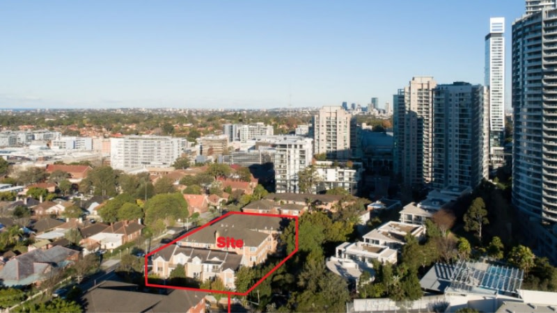 image of a couple of flats in chatswood and townhouses which are brown against the backdrop of highrise apartments.