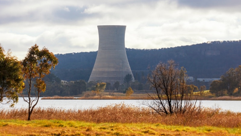 a power plant cooling tower surrounded by Australian country landscape