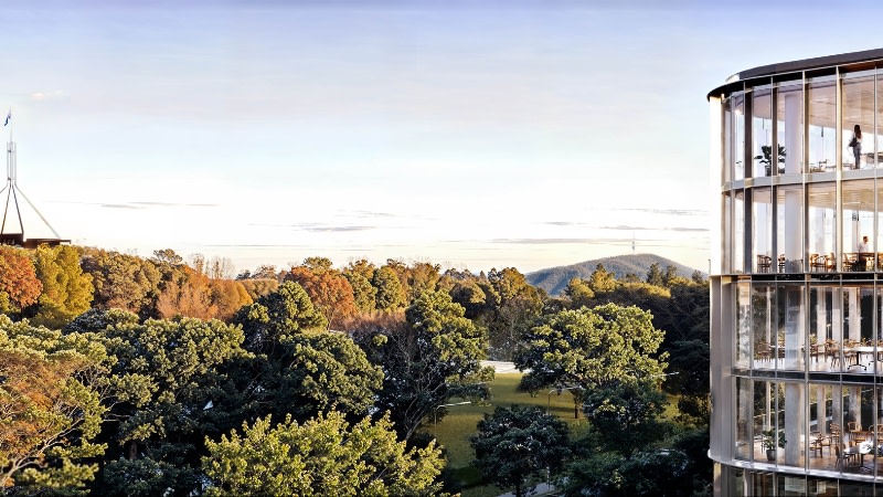 rendering of a new office building with the flag a top of parliament house visible nearby