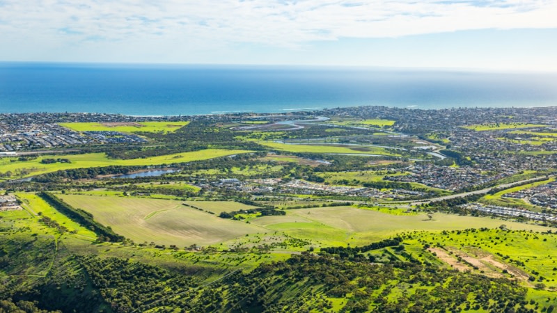 drone image showing a greenfield developable site with the beach in the distance