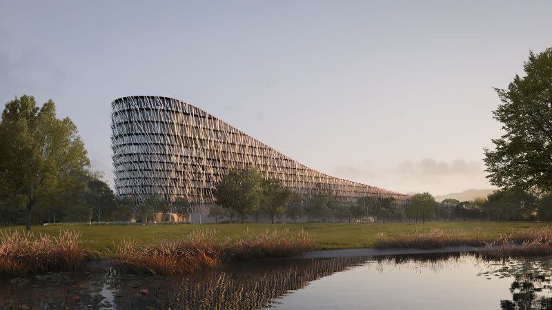 exterior of the future winter sports world in Penrith showing a resort which slopes down on one side and is surrounded by paddocks.  