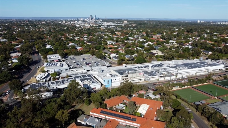 drone image of a large shopping centre with perth cbd in the background