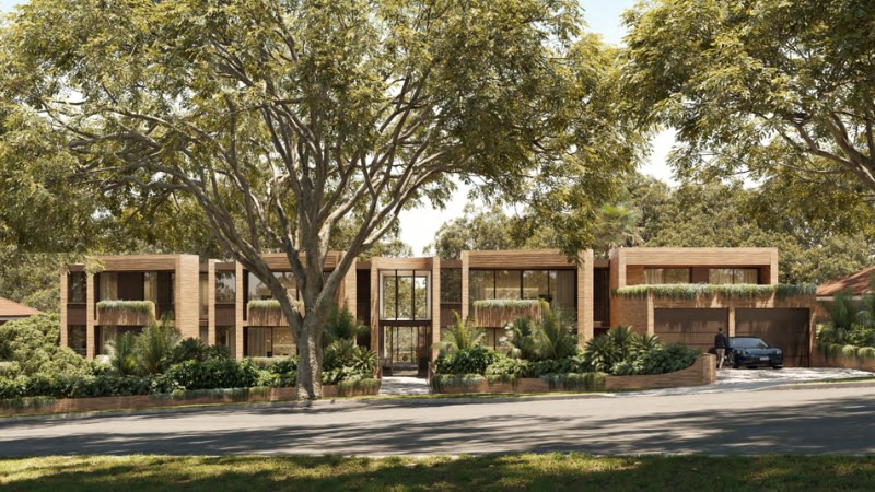 a long and flat, two storey looking building with driveways to the side, native australian trees at the front and a modern finish.