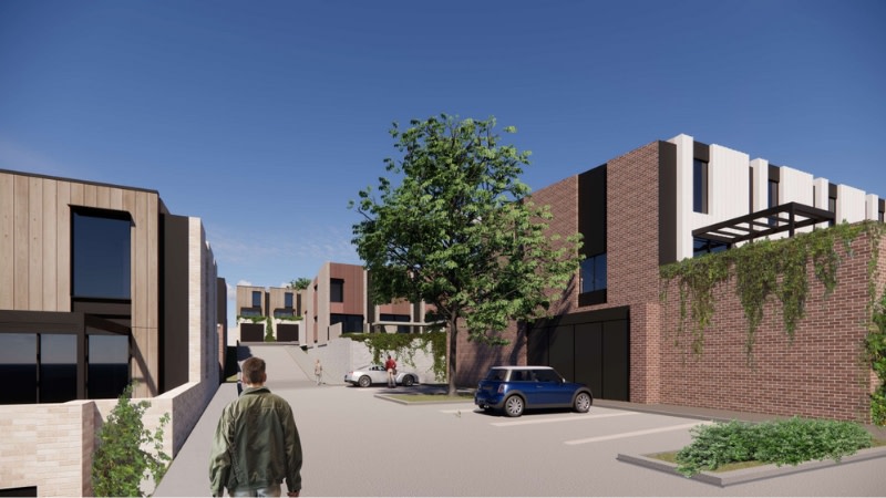 a driveway up a hill leading to multiple townhouse buildings. rendering