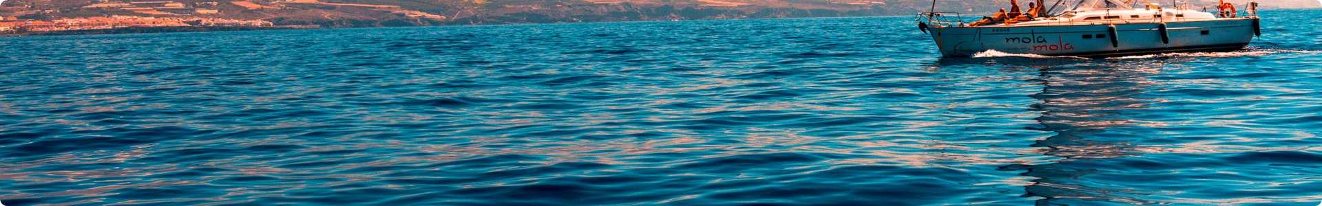 A sailboat sailing in a calm ocean with a good weather