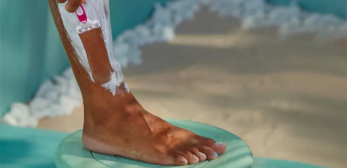 Woman shaving her creamed leg