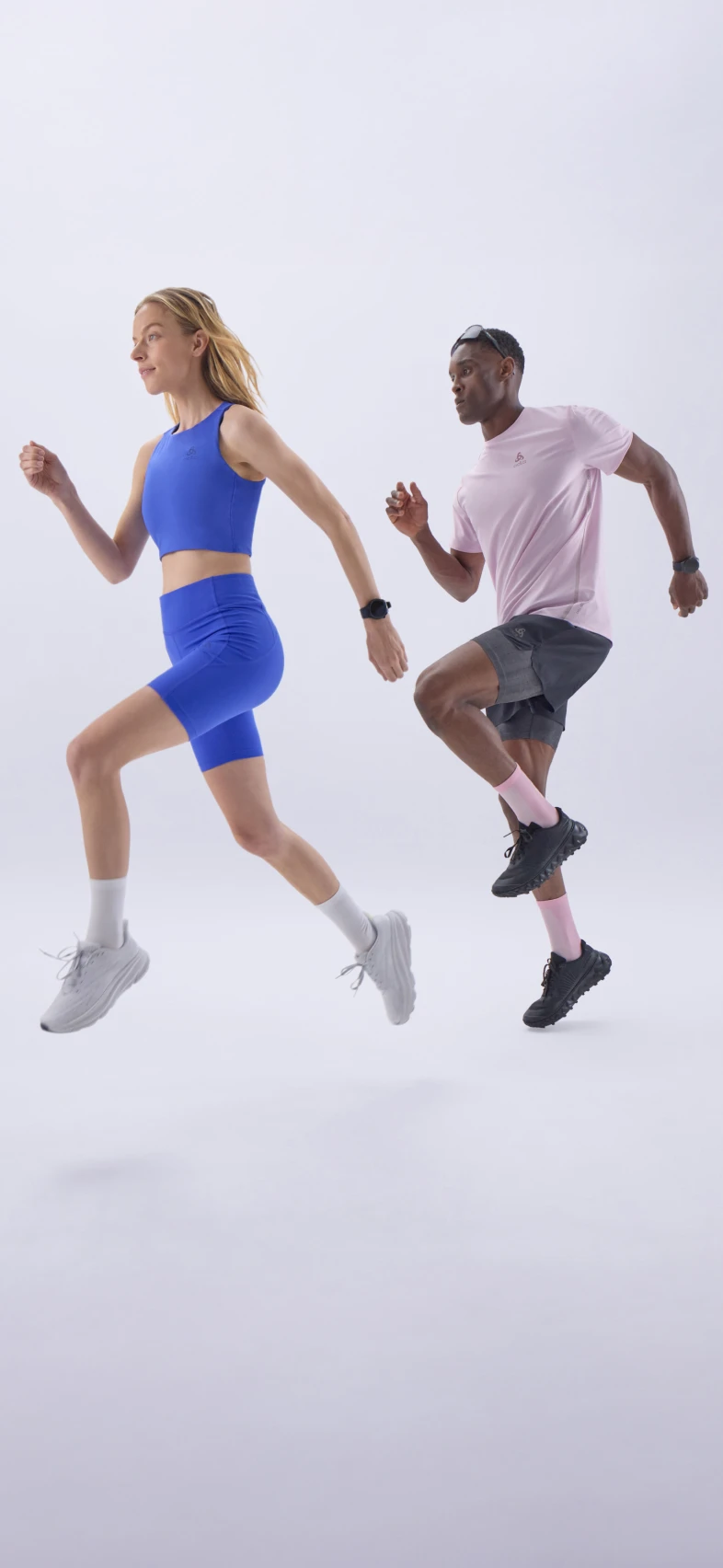 Woman in blue sportswear and man in pink shirt running energetically against a plain white background. (1)