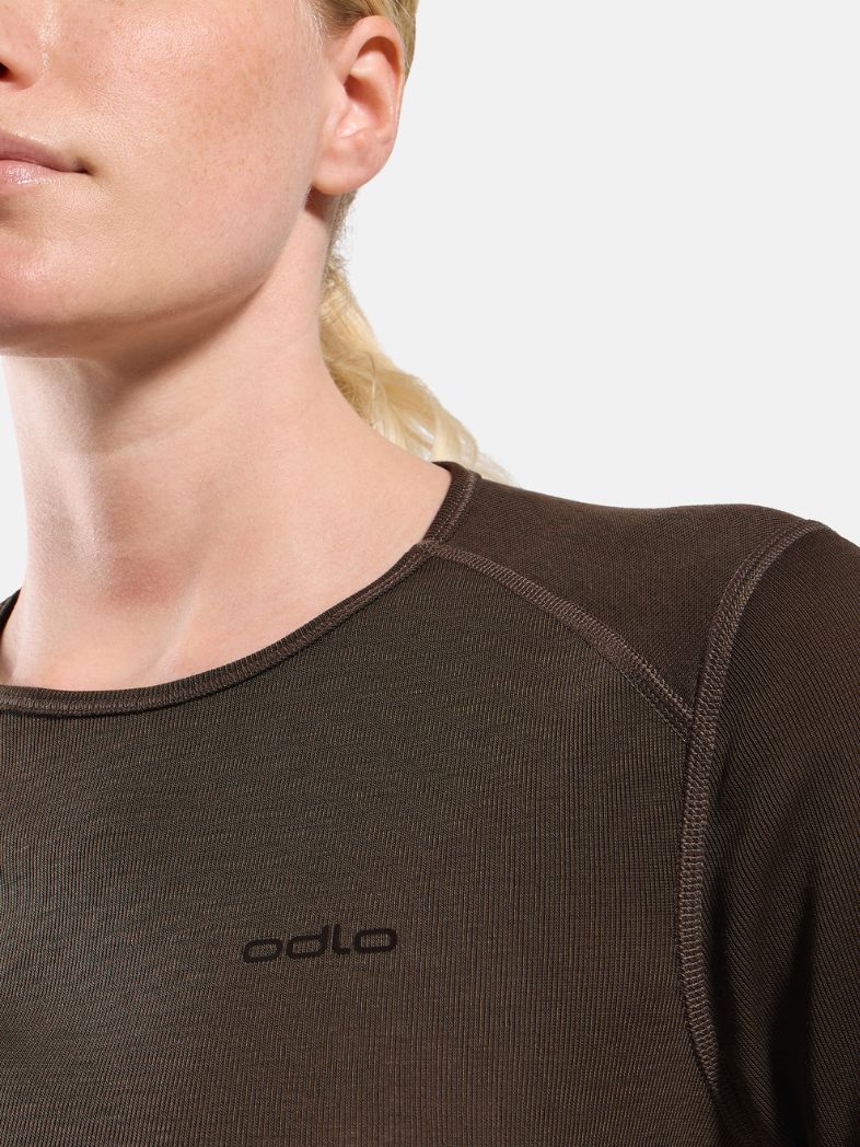 Blonde woman modelling a dark brown long-sleeved thermal top and matching leggings against a plain white background.