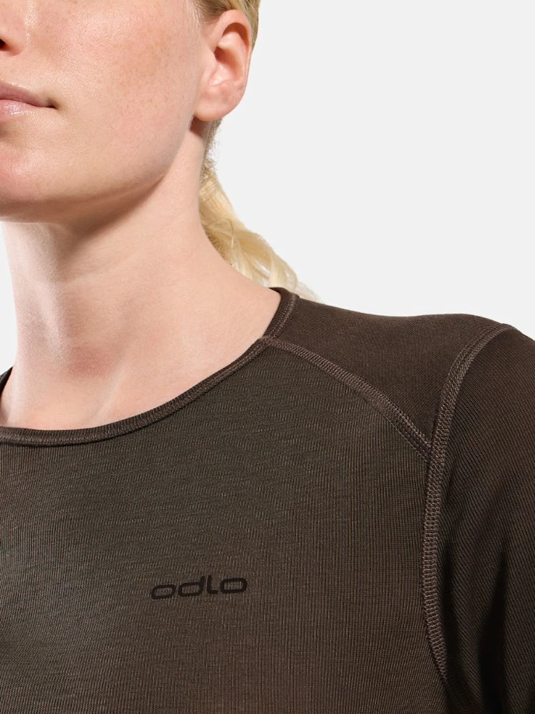 Blonde woman modelling a dark brown long-sleeved thermal top and matching leggings against a plain white background.