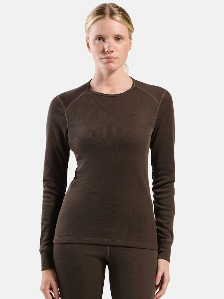 Close-up of a blonde woman wearing a dark brown ribbed Odlo athletic top against a plain light background.