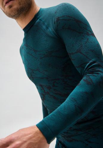Man in a tight long-sleeved blackcomb base layer with a black marble pattern and ribbed shoulders, posing in motion.