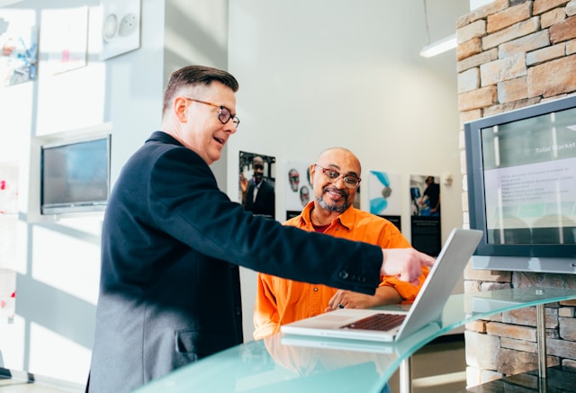 Man pointing at laptop screen smiling