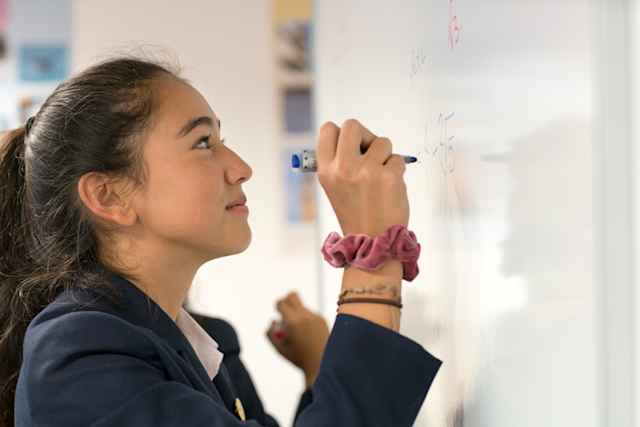 Malvern College - Student writes onto whiteboard durring lessons Malvern College - Student writes onto whiteboard durring lessons