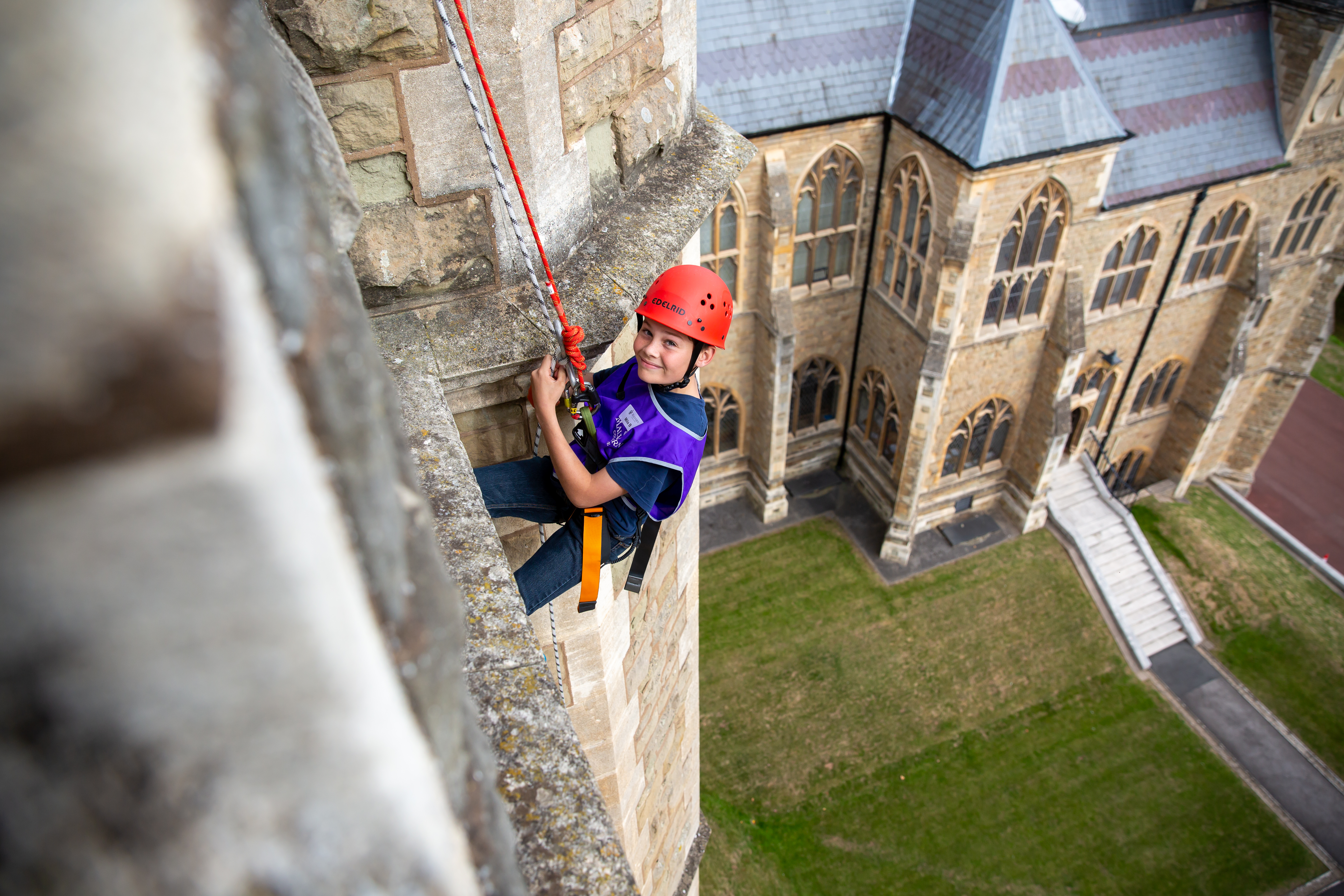 Malvern Summer School - Schueler wird von historischem Schulgebaude abgeseilt